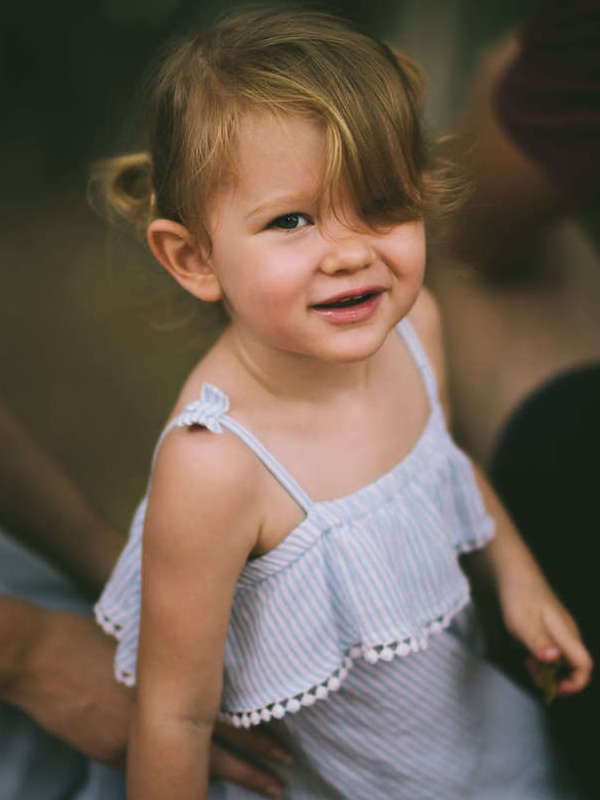 Smiling toddler girl in a white top