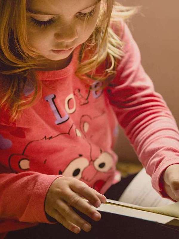Young girl reading a picture book