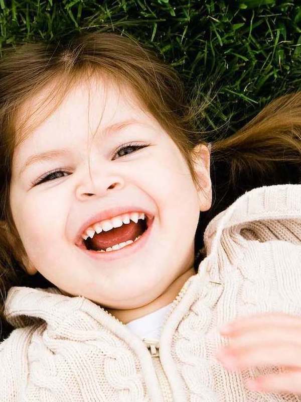 Happy child laughing outdoors, celebrating family connection for Father's Day