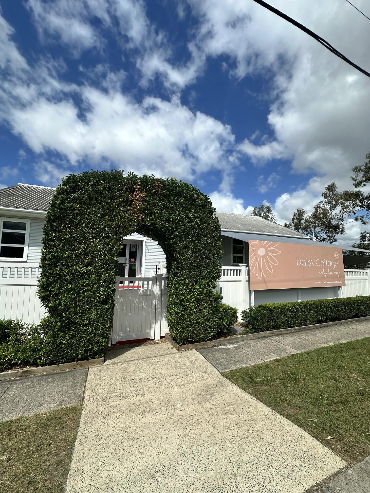 Daisy Cottage Early Learning entrance with hedge archway and signage