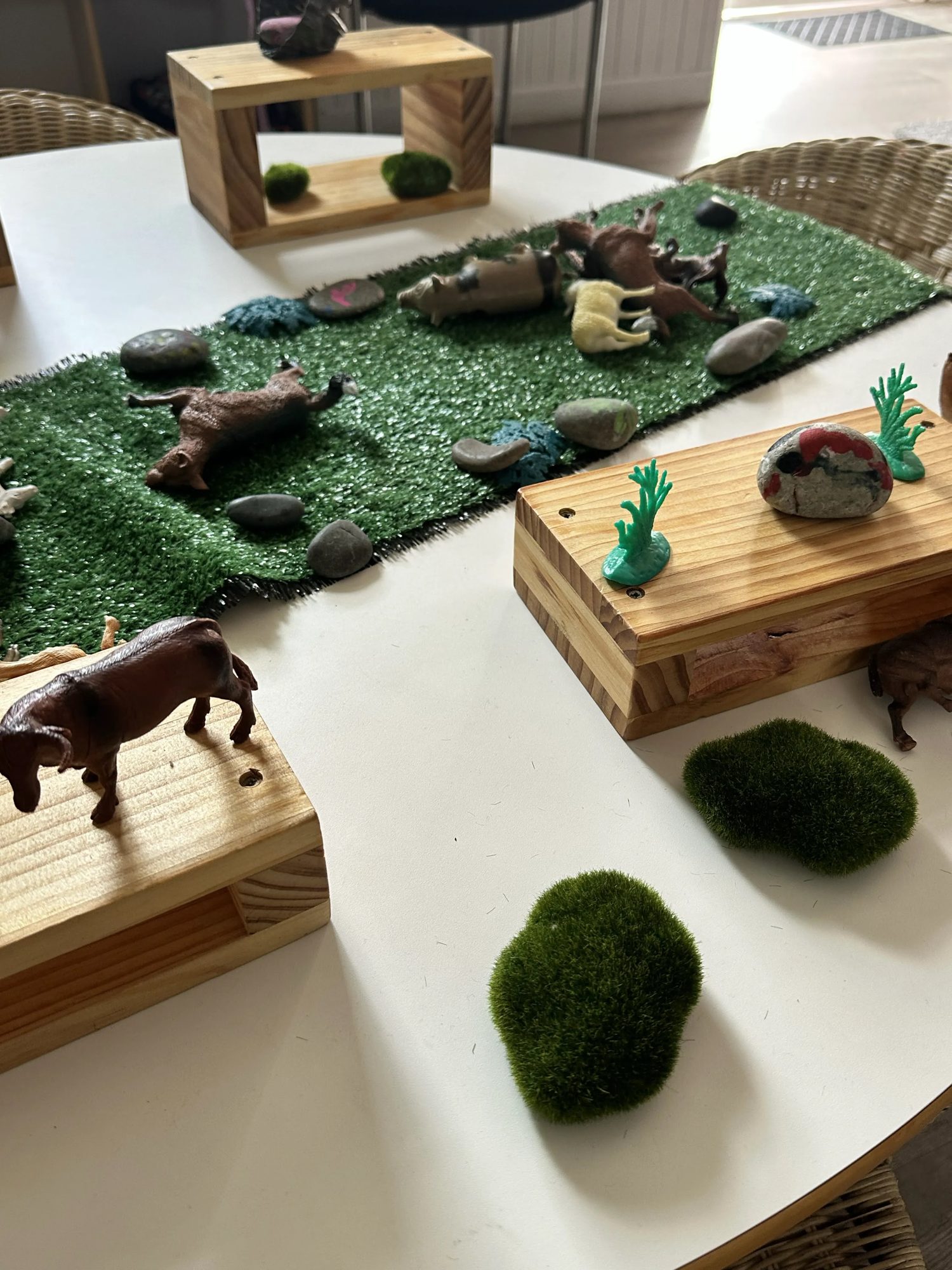 Small world play table with animal figures and natural materials at Daisy Cottage