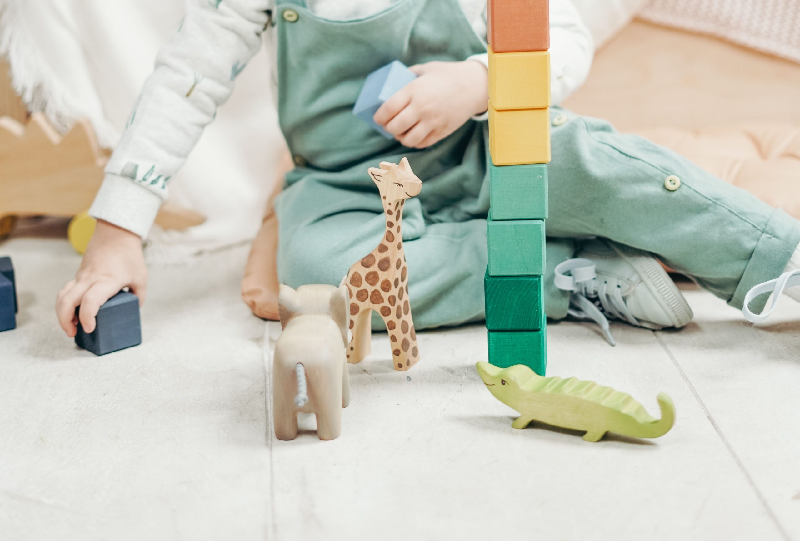 A child at Daisy Cottage Early Learning playing with wooden toy animals and blocks