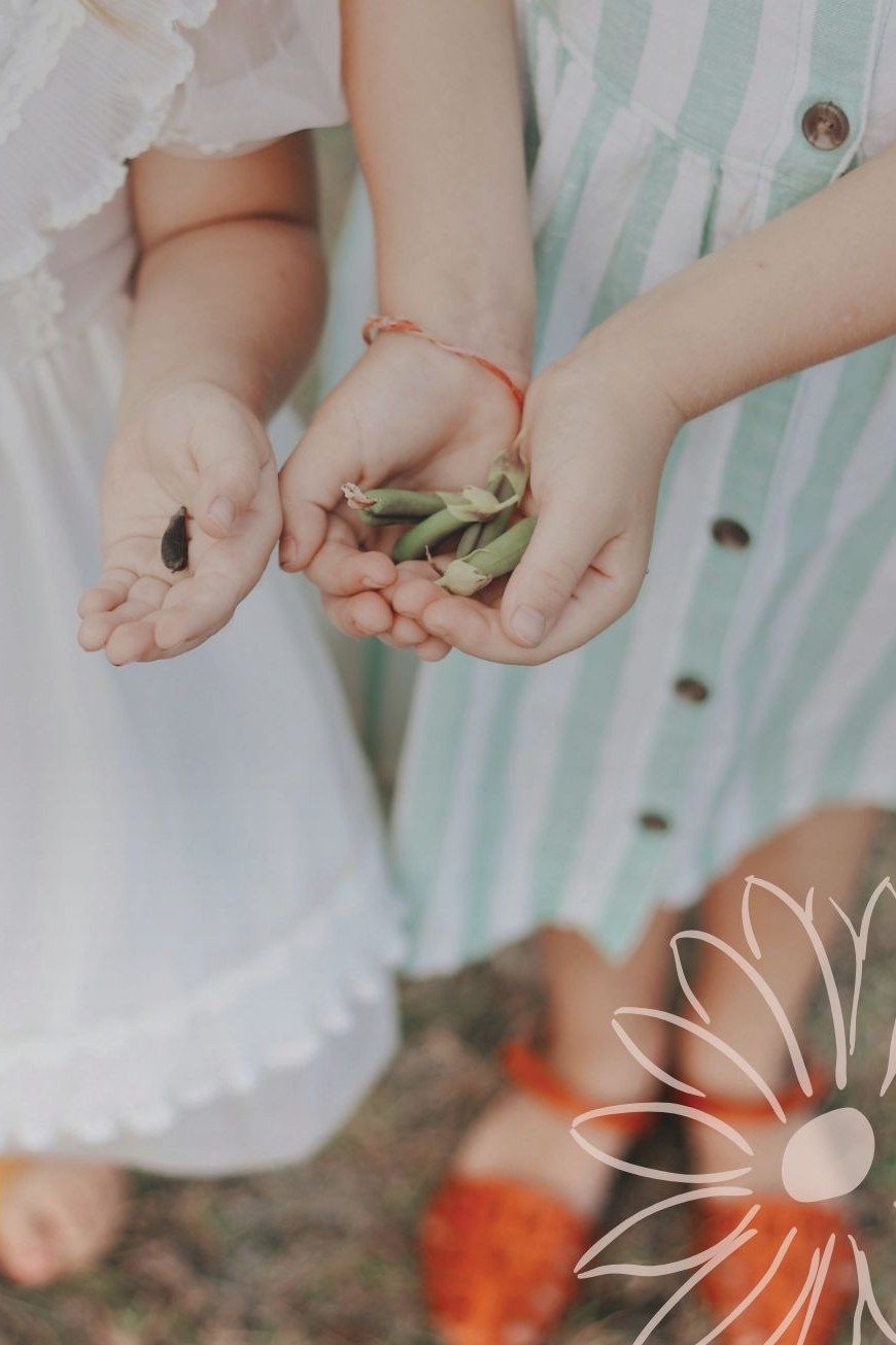 Two children holding freshly picked garden peas at Daisy Cottage Early Learning, Stafford